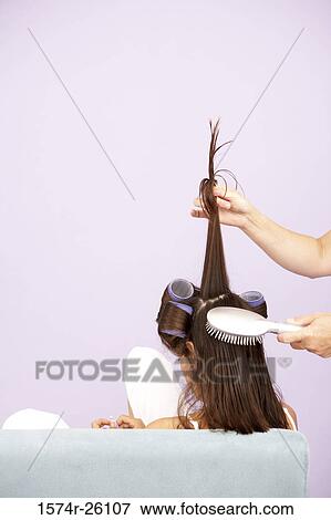 Female hair dresser styling a girl's hair View Large Photo Image Stock Photo - Female hair dresser styling a girl's hair. Fotosearch