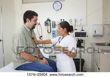Female nurse examining a patient with a stethoscope View Large Photo Image Picture - Female nurse examining a patient with a stethoscope. Fotosearch