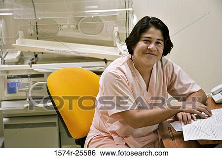 Female nurse sitting on a chair and smiling View Large Photo Image Stock Photograph - Female nurse sitting on a chair and smiling. Fotosearch
