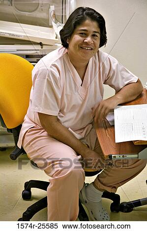 Female nurse sitting on a chair and smiling View Large Photo Image Stock Photography - Female nurse sitting on a chair and smiling. Fotosearch