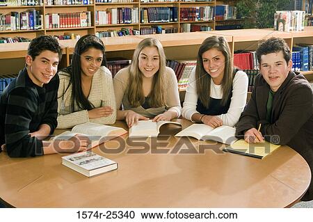 Five students sitting at a table in a library View Large Photo Image Stock Image - Five students sitting at a table in a library. Fotosearch