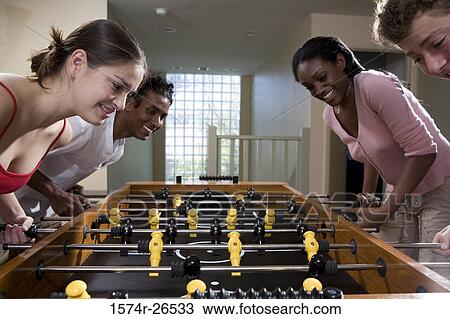 Four people playing foosball View Large Photo Image Stock Image - Four people playing foosball. Fotosearch