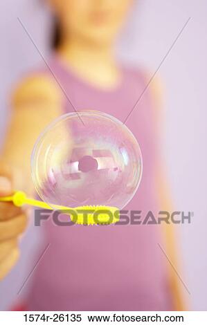 Girl holding a bubble on a bubble wand View Large Photo Image Stock Photography - Girl holding a bubble on a bubble wand. Fotosearch