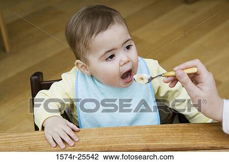 High angle view of a baby boy eating View Large Photo Image Stock Image - High angle view of a baby boy eating. Fotosearch