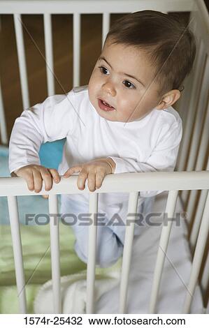 High angle view of a baby boy standing in a crib View Large Photo Image Stock Image - High angle view of a baby boy standing in a crib. Fotosearch