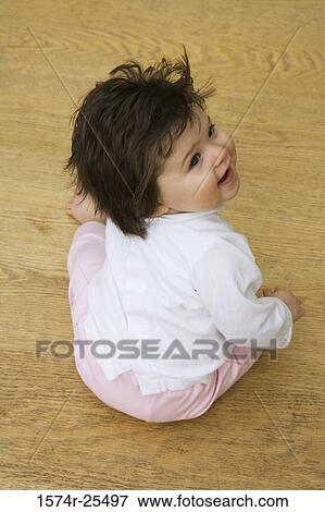 High angle view of a baby girl sitting View Large Photo Image Stock Photo - High angle view of a baby girl sitting. Fotosearch
