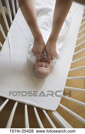 High angle view of a baby lying in a crib View Large Photo Image Stock Photo - High angle view of a baby lying in a crib. Fotosearch