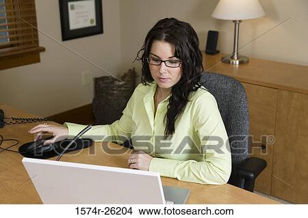 High angle view of a businesswoman sitting at a desk View Large Photo Image Picture - High angle view of a businesswoman sitting at a desk. Fotosearch