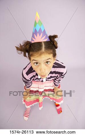 High angle view of a girl wearing a party hat and puckering View Large Photo Image Stock Image - High angle view of a girl wearing a party hat and puckering. Fotosearch