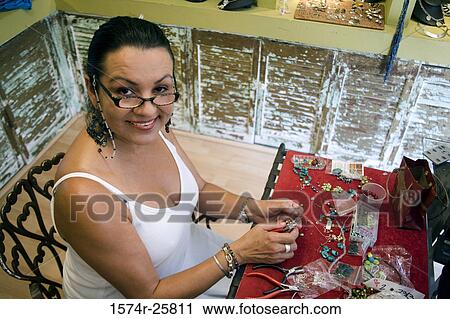 High angle view of a mature woman making jewelry in a souvenir store View Large Photo Image Stock Image - High angle view of a mature woman making jewelry in a souvenir store. Fotosearch