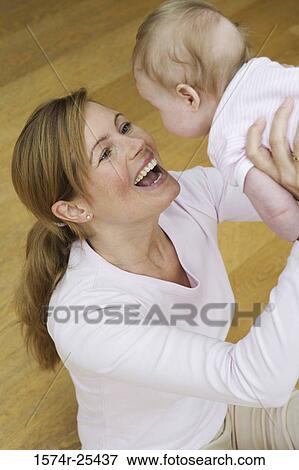 High angle view of a mid adult woman lifting her baby girl in the air View Large Photo Image Stock Photo - High angle view of a mid adult woman lifting her baby girl in the air. Fotosearch
