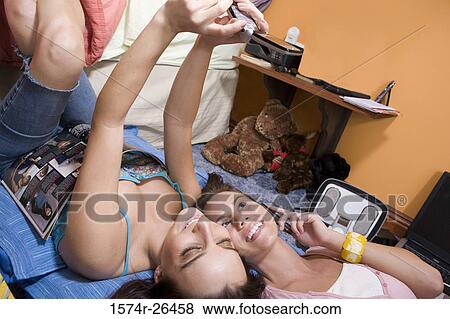 Stock Photo - High angle view of a teenage girl and a young woman photographing themselves. Fotosearch