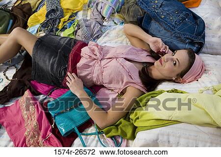 High angle view of a teenage girl lying on a bed and talking on a mobile phone View Large Photo Image Stock Image - High angle view of a teenage girl lying on a bed and talking on a mobile phone. Fotosearch