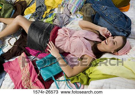 High angle view of a teenage girl lying on a bed and talking on a mobile phone View Large Photo Image Stock Image - High angle view of a teenage girl lying on a bed and talking on a mobile phone. Fotosearch