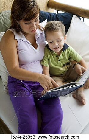 High angle view of a young woman with her son reading a book View Large Photo Image Stock Image - High angle view of a young woman with her son reading a book. Fotosearch