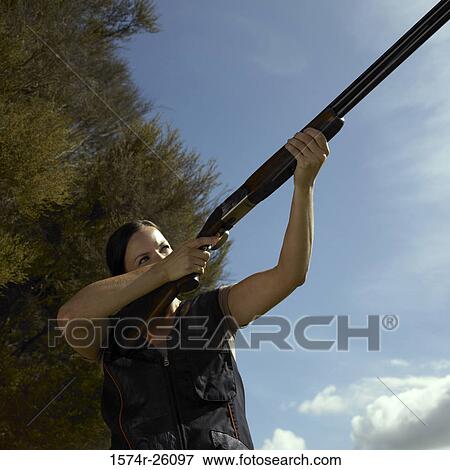 Low angle view of a female hunter aiming with her rifle View Large Photo Image Stock Photo - Low angle view of a female hunter aiming with her rifle. Fotosearch