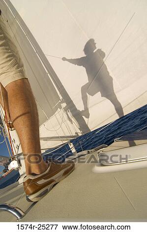 Low section view of a man standing on a sailboat View Large Photo Image Stock Photo - Low section view of a man standing on a sailboat. Fotosearch