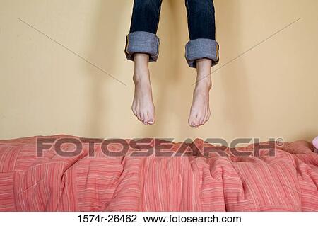 Low section view of a teenage girl jumping on a bed View Large Photo Image Stock Image - Low section view of a teenage girl jumping on a bed. Fotosearch
