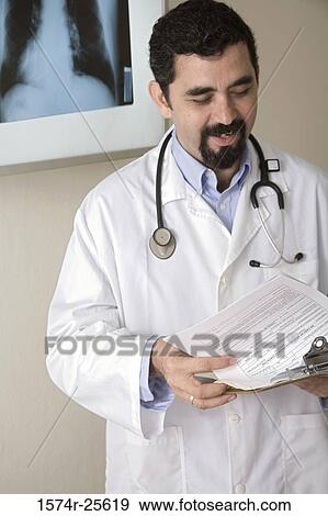 Stock Photo - Male doctor holding a clipboard. Fotosearch
