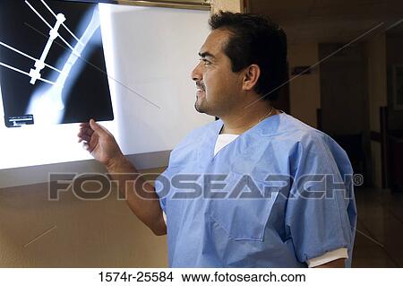 Male doctor looking at an x-ray image View Large Photo Image Picture - Male doctor looking at an x-ray image. Fotosearch