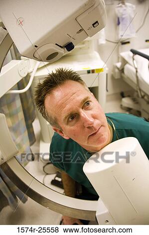 Male doctor looking at x-ray equipment View Large Photo Image Stock Photo - Male doctor looking at x-ray equipment. Fotosearch