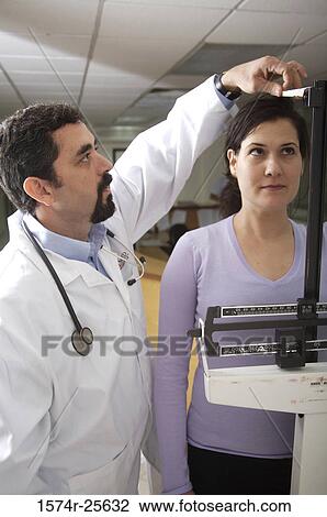 Male doctor measuring the height and weight of a patient View Large Photo Image Stock Image - Male doctor measuring the height and weight of a patient. Fotosearch
