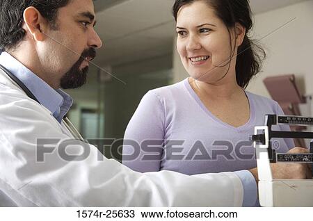 Male doctor measuring the weight of a patient View Large Photo Image Stock Image - Male doctor measuring the weight of a patient. Fotosearch