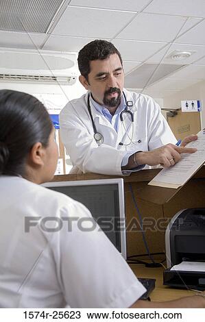 Male doctor showing the report to a female nurse View Large Photo Image Stock Image - Male doctor showing the report to a female nurse. Fotosearch