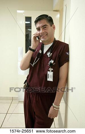 Stock Image - Male doctor talking on a mobile phone. Fotosearch