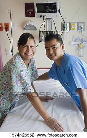 Male nurse and a female nurse leaning over a examination table View Large Photo Image Stock Image - Male nurse and a female nurse leaning over a examination table. Fotosearch