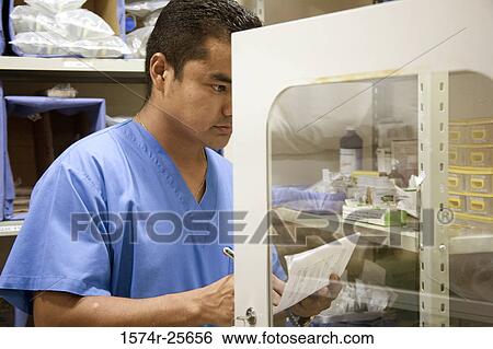 Male nurse making a list of medicine View Large Photo Image Stock Photograph - Male nurse making a list of medicine. Fotosearch