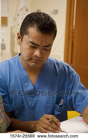 Male nurse reading the report of a patient View Large Photo Image Stock Photo - Male nurse reading the report of a patient. Fotosearch