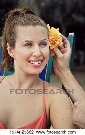 Man's hand putting a flower in a young woman's hair View Large Photo Image Stock Image - Man's hand putting a flower in a young woman's hair. Fotosearch