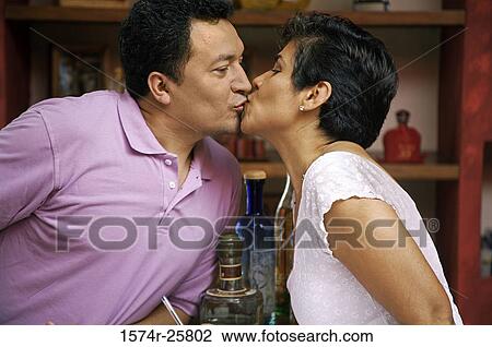 Stock Image - Mature couple kissing each other in a cafe. Fotosearch