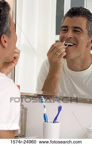 Mature man flossing his teeth View Large Photo Image Stock Image - Mature man flossing his teeth. Fotosearch
