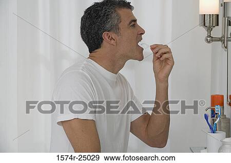Mature man flossing his teeth View Large Photo Image Stock Photo - Mature man flossing his teeth. Fotosearch