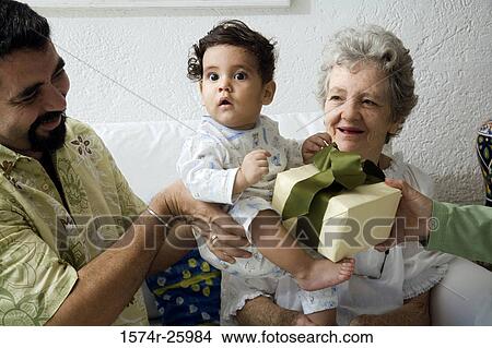 Picture - Mature man holding his baby and receiving a gift. Fotosearch