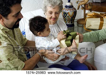 Stock Image - Mature man holding his son and receiving a gift. Fotosearch