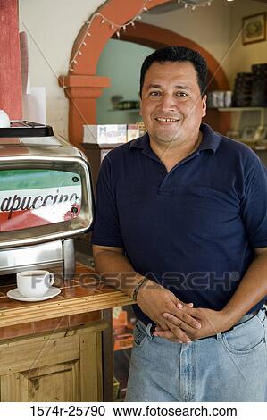 Mature man leaning against a counter in a cafe and smiling View Large Photo Image Stock Image - Mature man leaning against a counter in a cafe and smiling. Fotosearch