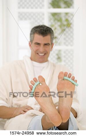 Mature man wearing toe dividers View Large Photo Image Stock Photo - Mature man wearing toe dividers. Fotosearch