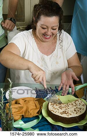 Mature woman cutting a cake with a knife and smiling View Large Photo Image Stock Image - Mature woman cutting a cake with a knife and smiling. Fotosearch