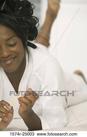 Mature woman lying on the bed and filing her fingernails View Large Photo Image Stock Image - Mature woman lying on the bed and filing her fingernails. Fotosearch