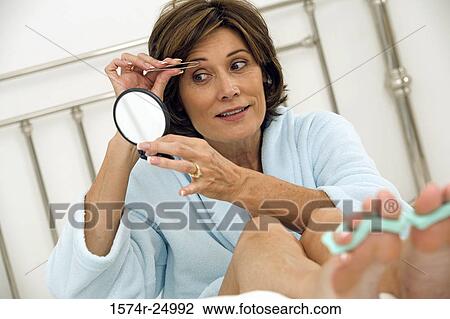 Mature woman plucking her eyebrows View Large Photo Image Stock Image - Mature woman plucking her eyebrows. Fotosearch