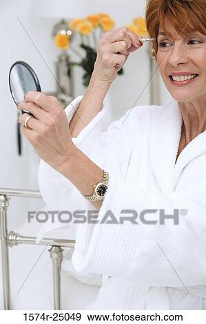 Mature woman plucking her eyebrows View Large Photo Image Stock Photo - Mature woman plucking her eyebrows. Fotosearch