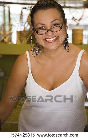 Stock Photography - Mature woman smiling in a souvenir store. Fotosearch