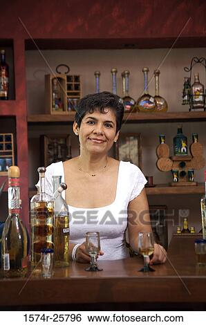 Mature woman standing in a cafe and smiling View Large Photo Image Stock Photograph - Mature woman standing in a cafe and smiling. Fotosearch