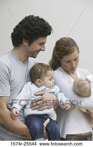 Mid adult couple holding their children View Large Photo Image Picture - Mid adult couple holding their children. Fotosearch