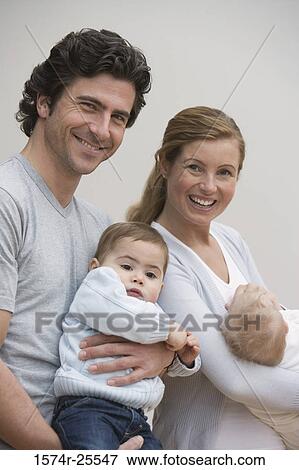 Mid adult couple holding their children View Large Photo Image Stock Photo - Mid adult couple holding their children. Fotosearch