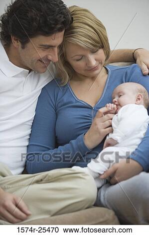 Mid adult couple looking at their baby View Large Photo Image Stock Image - Mid adult couple looking at their baby. Fotosearch