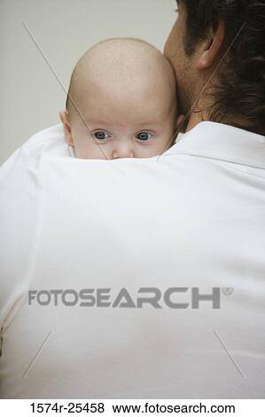 Mid adult man holding his baby View Large Photo Image Stock Photo - Mid adult man holding his baby. Fotosearch